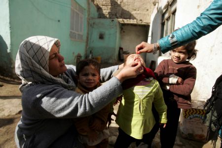 An Afghan health worker administers polio vaccine to a child in the old city of Kabul, capital of Afghanistan, November 16, 2009. 