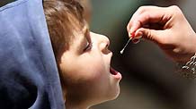 An Afghan health worker administers polio vaccine to a child in the old city of Kabul, capital of Afghanistan, November 16, 2009. Afghanistan launched a three-day nationwide polio vaccination in order to immunize children less than five-year-old against polio. Afghanistan aims to eradicate polio in the country till 2011.