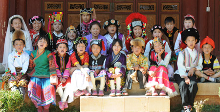 Orphan students on behalf of 18 ethnic minorities gather for a group photo-taking on the campus of the Orphanage School for Ethnic Minorities in Lijiang, southwest China's Yunnan Province, October 24, 2009. 