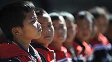 Photo taken on October 24, 2009 shows a group of pupils standing attention on the class of physical exercises at the Orphanage School for Ethnic Minorities in Lijiang, southwest China's Yunnan Province.