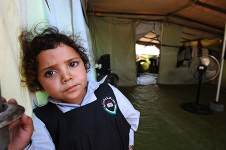 Mona Khader poses for a photo outside the tent, in which she lives in the Gaza Strip, on October 29, 2009. 