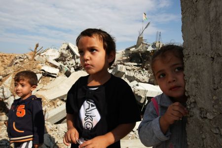 Mona Khader's cousins play at the debris near the tent, in which Mona lives in the Gaza Strip, on October 29, 2009. 