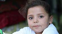 Mona Khader poses for a photo near the tent, in which she lives in the Gaza Strip, on October 29, 2009.