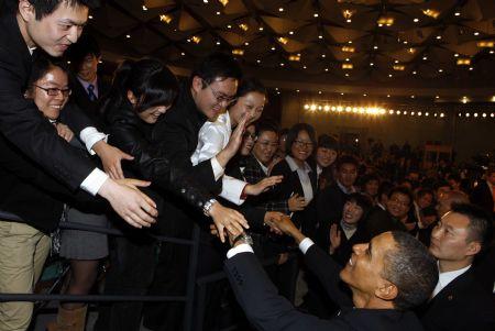 US President Barack Obama shakes hands with Chinese students after having a dialogue with Chinese youths at the Shanghai Science and Technology Museum during his four-day state visit to China, November 16, 2009.