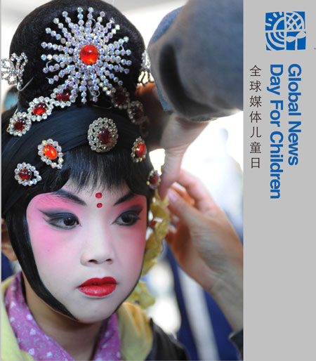 Liu Chenyan looks on as her teacher helps her put on the headdresses before a show in her school in Nanjing, east China's Jiangsu Province, October 26, 2009.