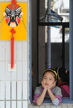 Liu Chenyan looks on through a window in her school in Nanjing, east China's Jiangsu Province, October 20, 2009.