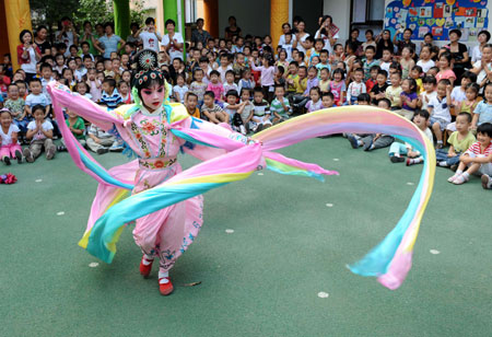 Liu Chenyan performs 'Celestial Beauty Scattering Flowers' during the opening ceremony for the Jiangsu Children's Peking Opera Training Course in a kindergarten in Nanjing, east China's Jiangsu Province, September 11, 2009.