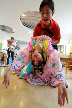 Liu Chenyan's teacher Wang Shanping gives instructions before the opening ceremony for the Jiangsu Children's Peking Opera Training Course in a kindergarten in Nanjing, east China's Jiangsu Province, September 11, 2009.