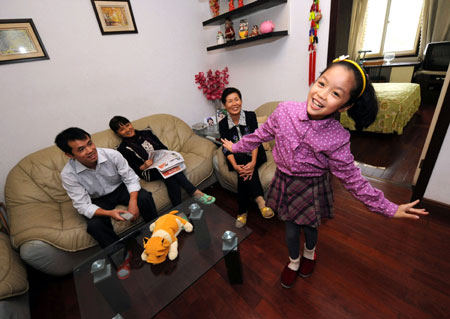 Liu Chenyan performs for her parents and grandma at home in Nanjing, east China's Jiangsu Province, October 24, 2009. 