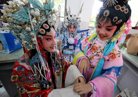 Liu Chenyan looks at the beautiful costume of her fellow in Nanjing, east China's Jiangsu Province, October 15, 2009. 