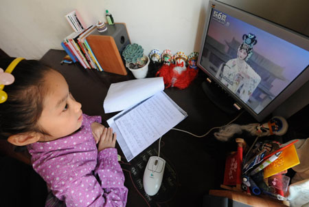 Liu Chenyan follows a video clip of 'Celestial Beauty Scattering Flowers' on computer in Nanjing, east China's Jiangsu Province, October 24, 2009. 