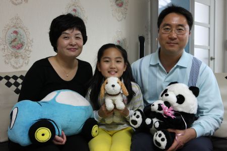 South Korean girl Lin Su Ting poses for photos with her parents at home in Seoul, capital of South Korea, November 1, 2009. 