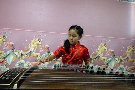 South Korean girl Lin Su Ting practises playing guzheng, or traditional Chinese zither, at home in Seoul, capital of South Korea, November 1, 2009.