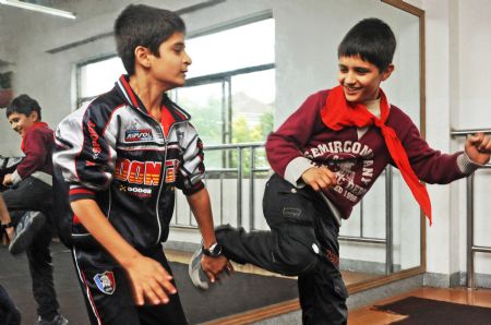 Sanlong (R) and an Afghan classmate practise kungfu in Wu'ai Primary School in Yiwu City, east China's Zhejiang Province, November 13, 2009.