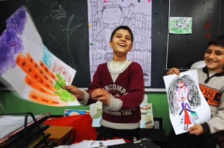 Sanlong (L) and his brother imitate the teacher teaching in painting class in Wu'ai Primary School in Yiwu City, east China's Zhejiang Province, November 13, 2009.