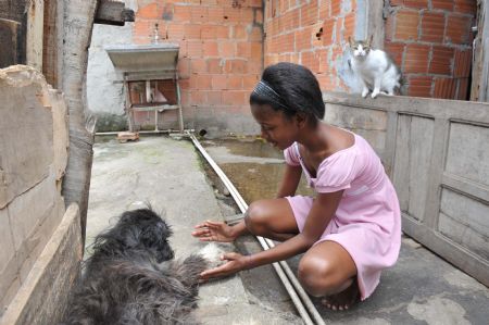 Photo taken on October 5, 2009 shows Maria Luisa plays with a dog at home in Rio De Janeiro of Brazil.