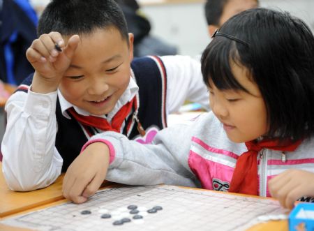 Xu Zhongzheng plays Chinese chess with a classmate during break in the New Primary School of Dujiangyan City of Chengdu, capital of southwest China's Sichuan Province, November 11, 2009. 