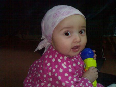 This picture taken on December 13, 2008 shows my cousin with a cute bandana plays with a toy microphone.