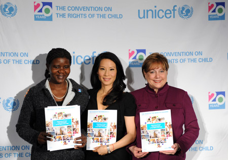 (R to L) Ann M. Veneman, executive director of the UN Children's Fund (UNICEF), UNICEF Goodwill Ambassador and actor Lucy Liu and Grace Akallo, former child soldier from Uganda, show 'The State of the World's Children' reports to the media during a news conference at the UNICEF headquarters in New York November 19, 2009.