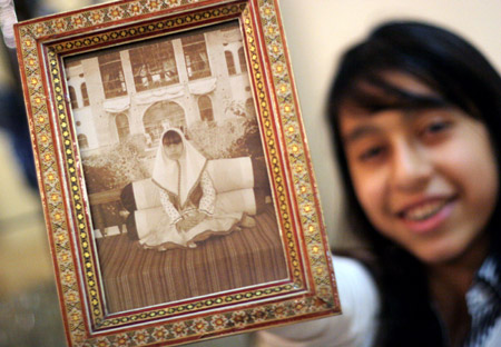 Rasa forouzan, a 12-year-old Iranian girl, displays the photo in which she dressed up with traditional clothes, in Teheran, capital of Iran, November 19, 2009.