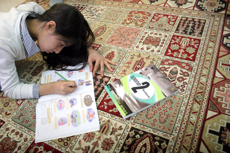 Rasa forouzan, a 12-year-old Iranian girl, does her homework on a traditional Persian carpet, in Teheran, capital of Iran, November 19, 2009.