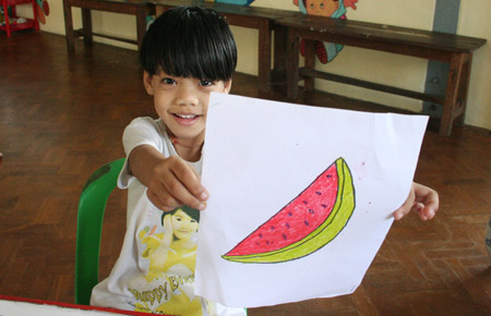 A child shows a picture she drew at the Htauk Kyant Orphanage in Yangon, Myanmar, on November 18, 2009.