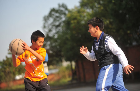 Liu Danyang (R) plays basketball at school November 2, 2009 in Yichang, city of central China's Hubei Province. 