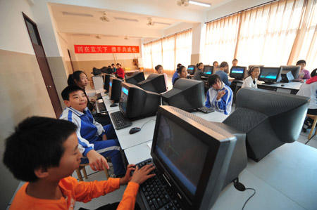 Liu Danyang (L2) reacts during his computer class at school on November 2, 2009 in Yichang, city of central China's Hubei Province.