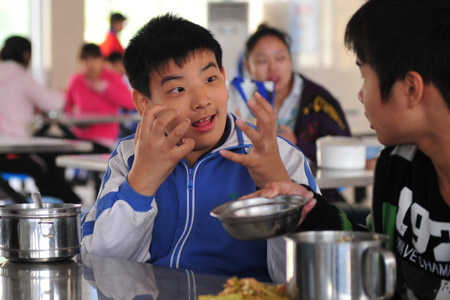 Liu Danyang (L) communicates with his classmate using finger language at school on November 2, 2009 in Yichang, city of central China's Hubei Province. 