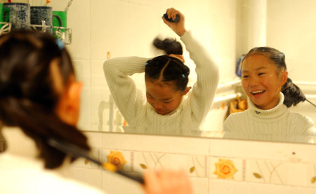 Cebae Zhoema and Namgyal Zhoema, a pair of twin girls of the Tibetan ethnic group who are both pupils of Grade 5 at the No.1 Elementary School of Lhasa, wash after they get up at their home in Lhasa, southwest China's Tibet Autonomous Region, November 20, 2009. 