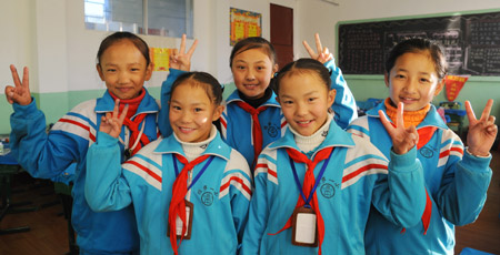 Cebae Zhoema (L2) and Namgyal Zhoema (R2), a pair of twin girls of the Tibetan ethnic group who are both pupils of Grade 5 at the No.1 Elementary School of Lhasa, pose a group photo with classmates, in Lhasa, southwest China's Tibet Autonomous Region, November 20, 2009.