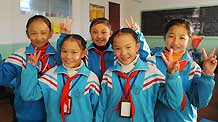 Cebae Zhoema (L2) and Namgyal Zhoema (R2), a pair of twin girls of the Tibetan ethnic group who are both pupils of Grade 5 at the No.1 Elementary School of Lhasa, pose a group photo with classmates, in Lhasa, southwest China's Tibet Autonomous Region, November 20, 2009.