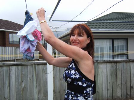 This photo I took on October 26, 2009 shows my mother hanging up laundry. She does laundry almost everyday. She takes good care of us and the whole family. She loves reading and helping others. 