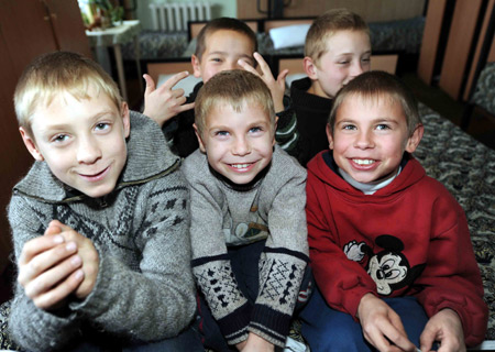 Ten-year-old Danil (1st R, front) and his younger brother Sacha (2nd R, front) pose for a photograph with their friends at the dorm of Voenno-antonovskiy Orphan School in Bishkek, capital of Kyrgyzstan, November 19, 2009.