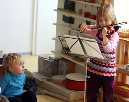 Charlotte Piotrowski plays the violin in front of her teacher and classmates in the Music Kindergarten in Berlin, capital of Germany, on November 12, 2009. 