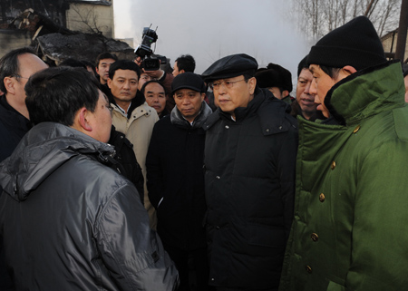 Chinese Vice Premier Zhang Dejiang (3rd R front) listens to rescuers' report at the site of a coal mine accident in Hegang City, northeast China's Heilongjiang Province, on November 21, 2009.