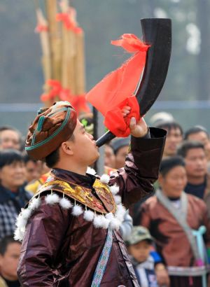 A man blows the horn to pray for good luck and bumper harvest during the Lusheng and Horse Fight Festival held in the Sports Park in Rongshui Miao Autonomous County, southwest China's Guangxi Zhuang Autonomous Region, November 21, 2009. 