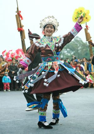 A girl of the Miao ethnic group performs lusheng dance during the Lusheng and Horse Fight Festival held in the Sports Park in Rongshui Miao Autonomous County, southwest China's Guangxi Zhuang Autonomous Region, November 21, 2009.
