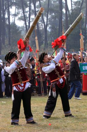 Two men blow the lusheng musical pipe to pray for good luck and bumper harvest during the Lusheng and Horse Fight Festival held in the Sports Park in Rongshui Miao Autonomous County, southwest China's Guangxi Zhuang Autonomous Region, November 21, 2009.