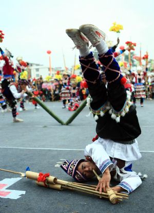 A performer plays the lusheng musical pipe during the Lusheng and Horse Fight Festival held in the Sports Park in Rongshui Miao Autonomous County, southwest China's Guangxi Zhuang Autonomous Region, November 21, 2009.