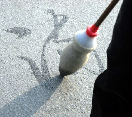 Photo taken on October 28, 2009 by Li Minghao shows an elderly man writing Chinese characters on the ground with a brush in Harbin, northeast China's Heilongjiang Province.