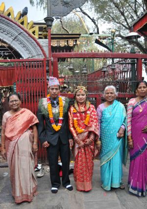 A newlywed couple pose for a group photo with their family members after their wedding ceremony in a temple in Kathmandu, capital of Nepal, on November 21, 2009. 