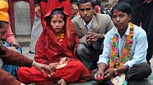 A bride and a bridegroom sit during their wedding ceremony in a temple in Kathmandu, capital of Nepal, on November 21, 2009. According to the Nepali calendar, it is inappropriate for people to get married in the first seven months of a year.