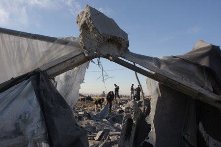 Palestinians inspect the ruins caused by Israeli airstrikes on tunnels in Rafah in the southern Gaza Strip bordering Egypt November 22, 2009.