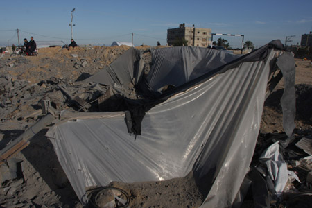 Palestinians inspect the ruins caused by Israeli airstrikes on tunnels in Rafah in the southern Gaza Strip bordering Egypt November 22, 2009. At least 10 Palestinians were wounded in the Israeli airstrikes on various targets in the Gaza Strip early Sunday, witnesses and medical sources said.