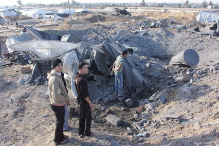 Palestinians inspect the ruins caused by Israeli airstrikes on tunnels in Rafah in the southern Gaza Strip bordering Egypt November 22, 2009. 