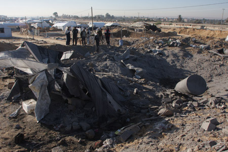 Palestinians inspect the ruins caused by Israeli airstrikes on tunnels in Rafah in the southern Gaza Strip bordering Egypt November 22, 2009.