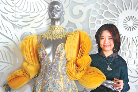 Haute couture designer Guo Pei poses with a dress of her creation in her Beijing studio.