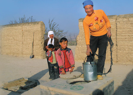 Lan Wuhua, 31, uses a fresh water well plumbed by Oxfam Hong Kong in Huolianwan Village, Gansu Province, where residents have struggled to get access to clean drinking water.