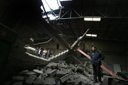 Palestinians check the site damaged by Israeli air strike in Gaza City, November 24, 2009. The Israeli army said it carried out three air strikes in the Gaza Strip, targeting the facility for manufacturing weapons and weapons-smuggling tunnels in response to rocket attacks on southern Israel from the Gaza Strip on the previous day.